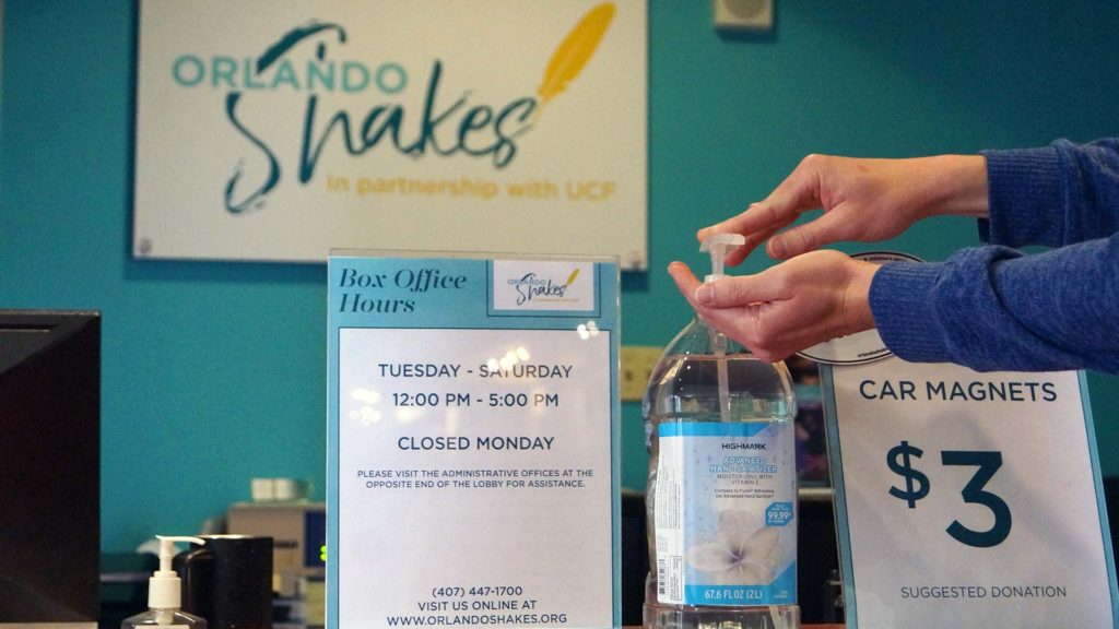 A patron uses hand sanitizer available at the Box Office.