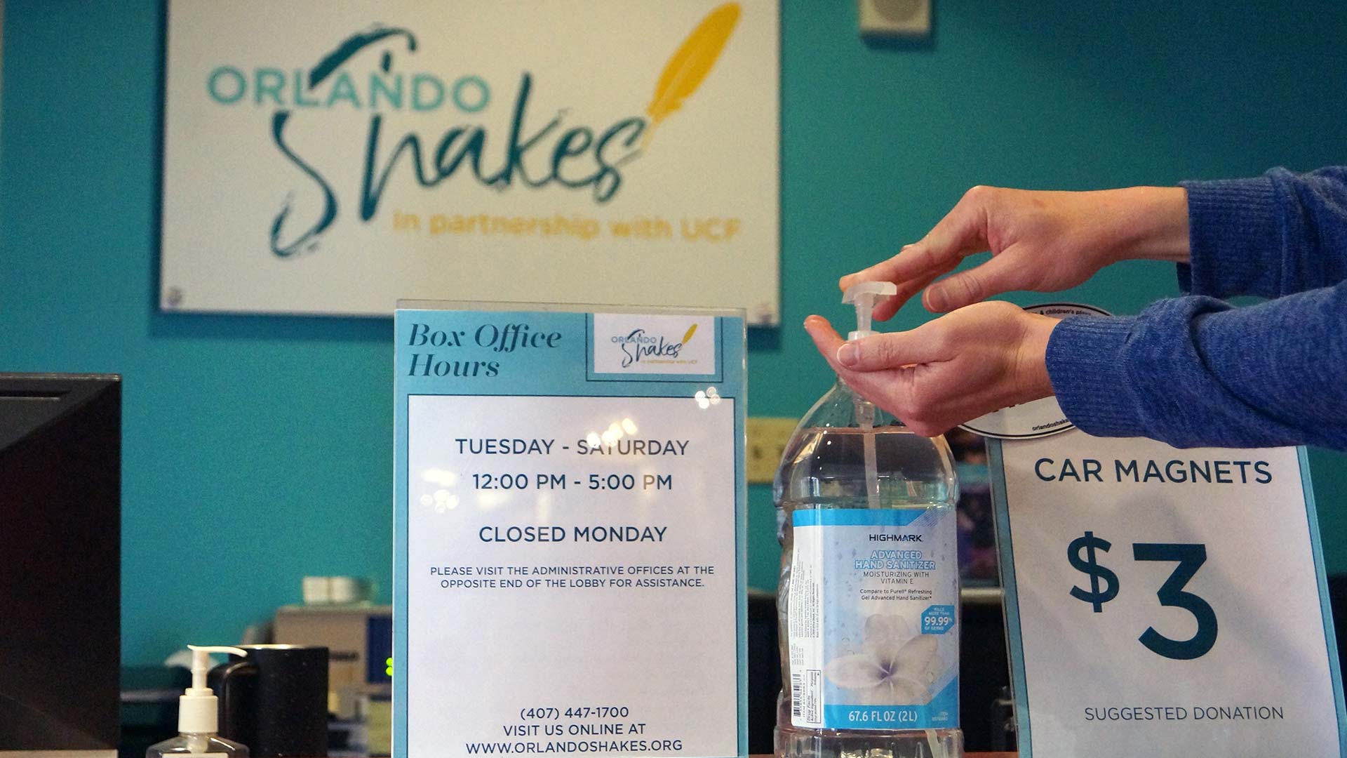 A patron uses hand sanitizer available at the Box Office.